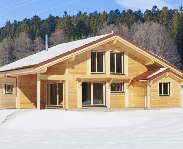 Chalet traditionnel en poteau-poutre sous la neige