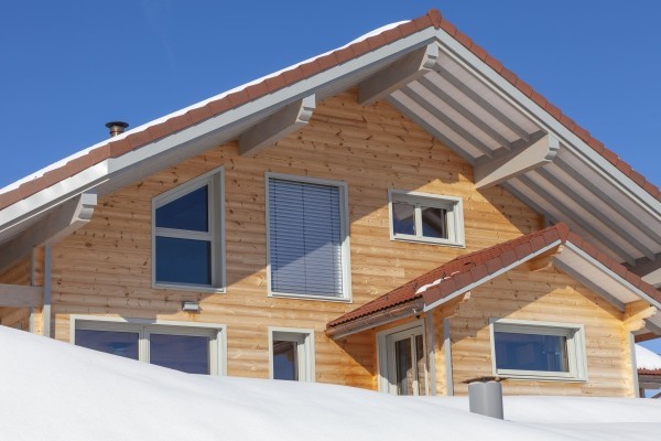 Chalet traditionnel en madriers dans un paysage enneigé de Franche-Comté (Lièvremont)