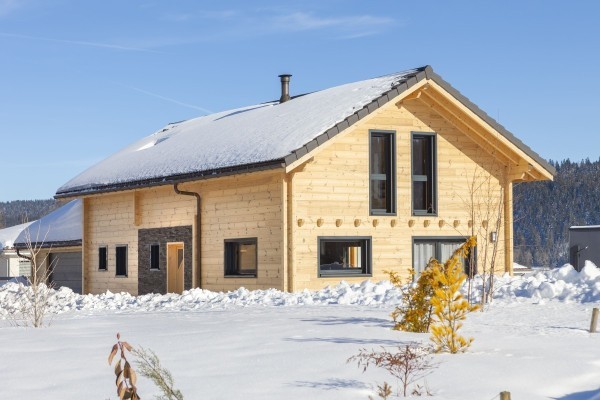 Alliance entre pierres et madrier dans un paysage enneigé (Les Etraches)