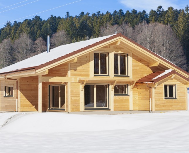 Chalet traditionnel en poteau-poutre sous la neige